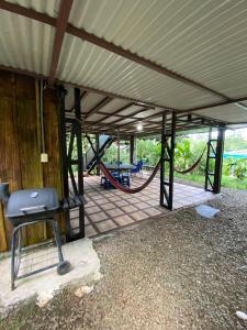 a covered patio with a hammock and a swing set at Tropical Quiet Retreat in Venecia