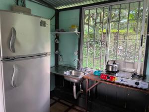a kitchen with a sink and a refrigerator at Tropical Quiet Retreat in Venecia