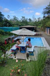 two women sitting at a table next to a pool at Tropical Quiet Retreat in Venecia