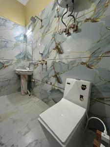 a bathroom with a white toilet and a sink at Prabhukripa Vilas Homestay in Mathura +21 photos
