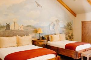 a bedroom with two beds and a painting on the wall at Wildcatter Ranch and Resort in Graham +142 photos