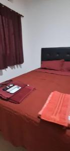 a bed with red sheets and red towels on it at La Guarida 3 in Concepción