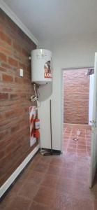 a room with a water heater and a brick wall at La Guarida 3 in Concepción