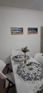 a dining room table with a vase of flowers on it at La Guarida 3 in Concepción