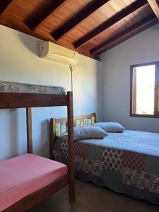 a bedroom with two bunk beds and a window at Residencial Casa Laranja - Casas na Praia da Ferrugem in Garopaba +25 photos