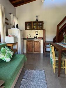 a kitchen with a table and a dining room at Residencial Casa Laranja - Casas na Praia da Ferrugem in Garopaba