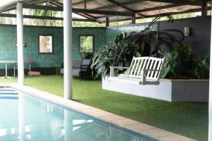 a swimming pool with a white bench next to a swimming pool at Tranquility Retreat in Mission Beach