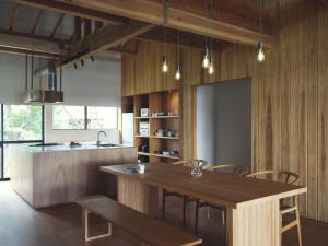 a dining room with a wooden table and chairs at SANU 2nd Home MON Amami Oshima in Tatsugo