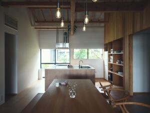 a kitchen with a table and chairs and a sink at SANU 2nd Home MON Amami Oshima in Tatsugo