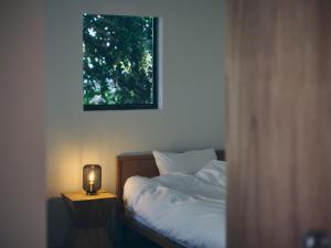 a bedroom with a bed with a candle on a table at SANU 2nd Home MON Amami Oshima in Tatsugo +12 photos