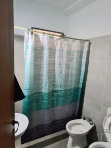 a bathroom with a shower curtain and a toilet at San Martin 40 in Villa Carlos Paz