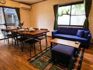 a living room with a blue couch and a table at Villa228KASAMA in Kasama