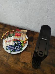 a remote control next to a plate of food at Smart Loft Studio Center Walking street in Chişinău