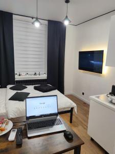 a room with a laptop on a table with a bed at Smart Loft Studio Center Walking street in Chişinău