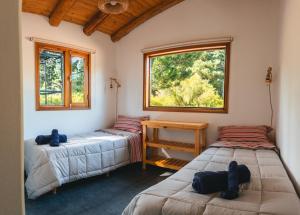 two beds in a room with two windows at Cabure in Epuyén