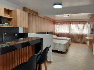 a room with a kitchen and a bedroom with a bed at Matrix Alojamiento in Punta Negra
