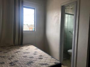 a bedroom with a bed and a window and a shower at Sobrado próximo ao mar em Salinas in Cidreira