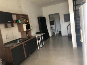 a kitchen with a sink and a table and a microwave at Sobrado próximo ao mar em Salinas in Cidreira +12 photos