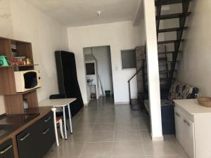 a kitchen and living room with a table and a microwave at Sobrado próximo ao mar em Salinas in Cidreira