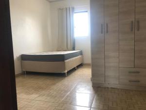 a bedroom with a bed and a window and cabinets at Sobrado próximo ao mar em Salinas in Cidreira
