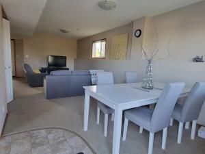 a living room with a white table and chairs at Quaint Lonsdale Suite in Red Deer