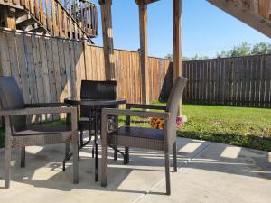 three chairs and a table on a patio at Quaint Lonsdale Suite in Red Deer