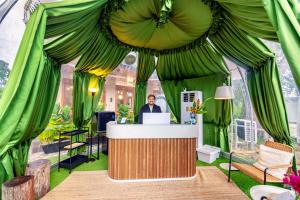 a man standing at a bar in a green tent at Nadi Glamping Suites, Auto-City in Perai