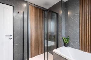 a bathroom with a shower and a tub and a sink at Paradykes House in Loanhead