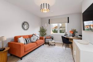 a living room with an orange couch and a table at Paradykes House in Loanhead