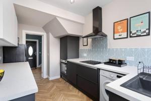 a kitchen with a sink and a stove top oven at Paradykes House in Loanhead +31 photos