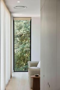 a living room with a couch and a large window at Treetop House in Crafers