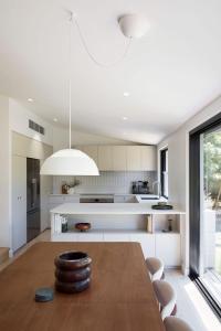 a kitchen with a wooden table and a largeandelier at Treetop House in Crafers