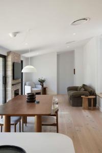 a living room with a table and a couch at Treetop House in Crafers