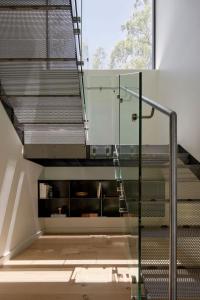 a glass staircase in a room with a window at Treetop House in Crafers +10 photos