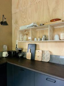 a kitchen with wooden cabinets and a counter top at Designed House With Recycled Details In Österlen in Köpingebro