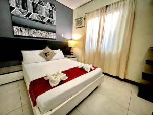 a bedroom with a large white bed with flowers on it at D'Goldwin Lodge in Coron