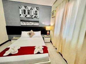 a hotel room with a bed with towels on it at D'Goldwin Lodge in Coron
