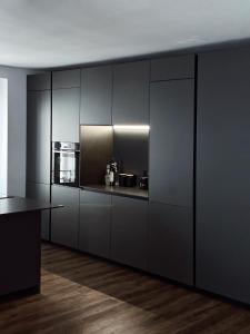 a kitchen with black cabinets and a counter at Paponena Holidays in Riva del Garda