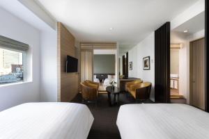 a hotel room with two beds and a desk at Palace Hotel Omiya in Saitama