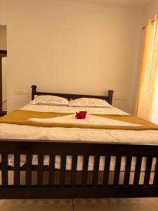 a bed with a blanket and a red flower on it at Florence Stays Munnar in Munnar