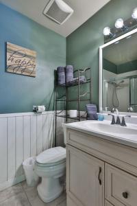 a bathroom with a toilet and a sink and a mirror at Spa Steps to Lift Private Spa BBQ Massage Chair in Big Bear Lake +32 photos