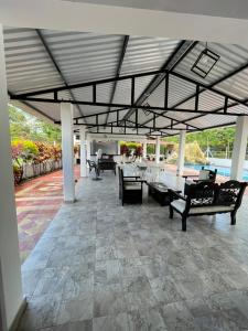 a patio with couches and tables and a roof at Finca Turística VILLA NELLA in Acacías
