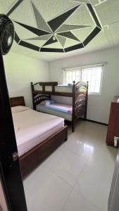 a bedroom with two beds and a ceiling fan at Finca Turística VILLA NELLA in Acacías