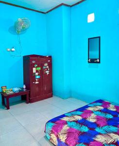 a room with a bed and a blue wall at Kopinka in Yogyakarta