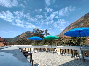 a row of tables and chairs with blue umbrellas at Nongkhiaw Chansai Guesthouse in Nongkhiaw +27 photos