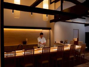 a man standing behind a table in a restaurant at Takanoya in Yuzawa +51 photos