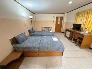 a room with two beds and a desk and a television at เพิ่มพูนแมนชั่น พิษณุโลก Phoempun Mansion in Sathani Phitsanulok +12 photos