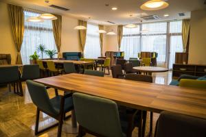 a conference room with tables and chairs and windows at Hotel Kapetanovina in Mostar