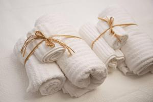 three towels with bows on them sitting on a bed at Paponena Holidays in Riva del Garda +40 photos