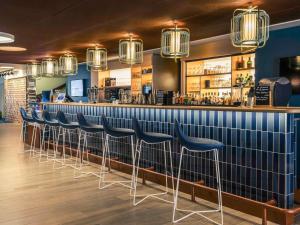 a row of blue stools at a bar at Mercure Toulouse Centre Saint-Georges in Toulouse